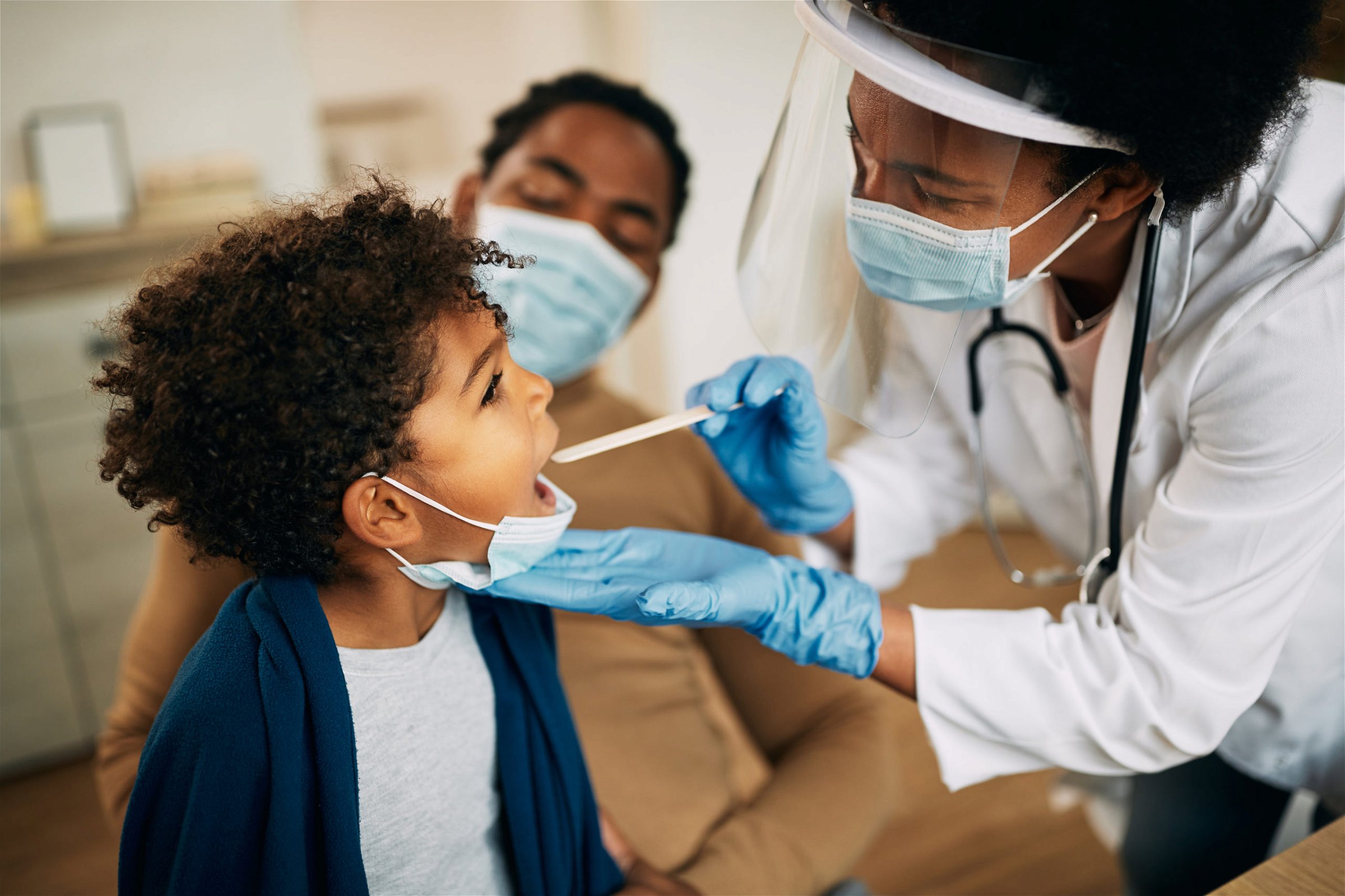 Pediatrician providing healthcare to a child in front of a parent